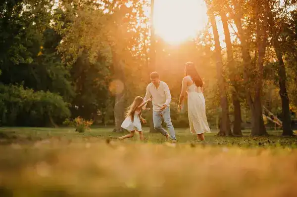 Familia feliz jugando en un parque, un signo que favorece la empatía en el aula