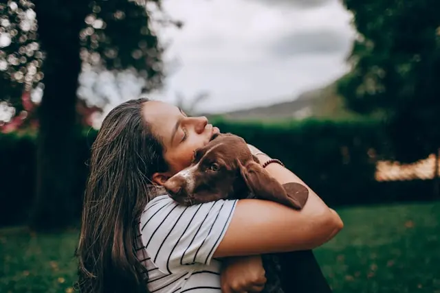 mujer abrazando a un perro