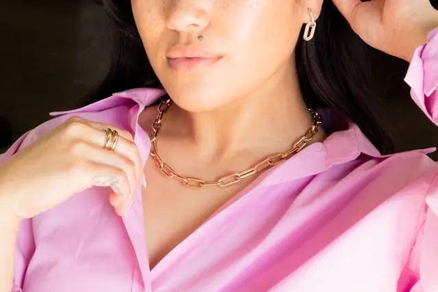 mujer vestida de rosado usando joyas de oro